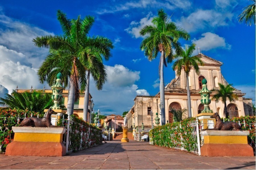View of a cathedral in Dominican Republic with a blue sky in the background and palm trees