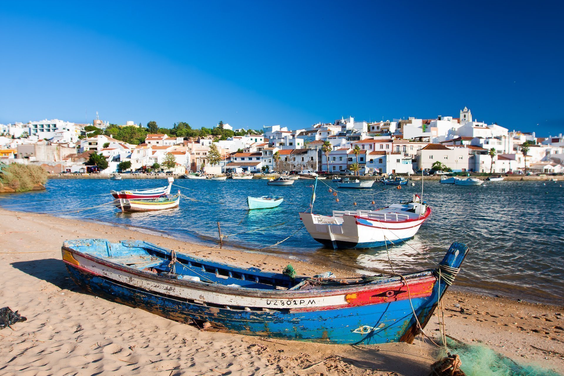 Ferragudo, Portugal - View of the village, sea and speedboats from the beach